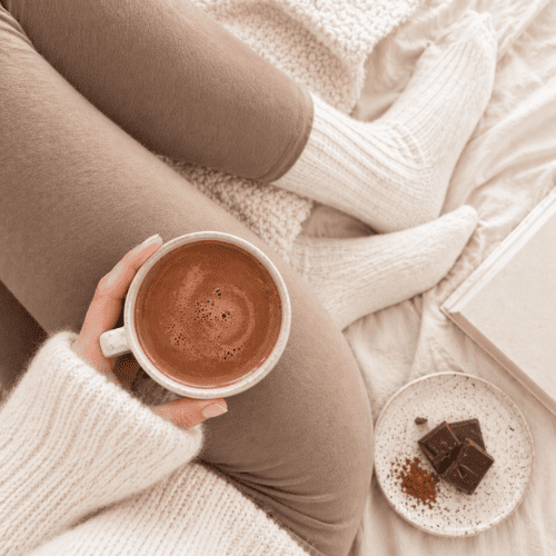 Gemütliche Selbstfürsorge während der Menstruation mit Tee und Decke, Ernährung während der Periode und weiblicher Zyklus im Alltag